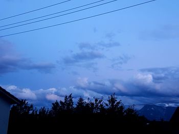 Low angle view of silhouette trees against sky