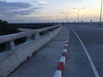 Road by bridge against sky during sunset