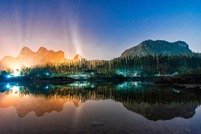 Scenic view of lake against sky at night