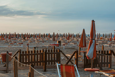 Wooden posts on beach against sky