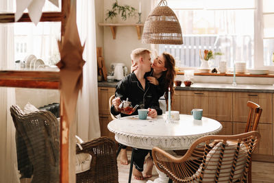 A couple in love have breakfast and drink tea in a decorated eco-style kitchen in a country house