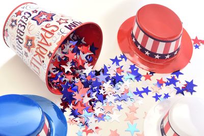 High angle view of multi colored decoration spilling from box on table