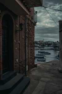 Buildings by sea against sky