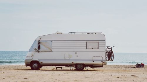 Vehicle on beach against sky