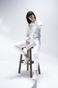 Side view of woman sitting on snow