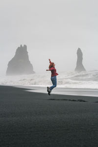 Jumping woman on reynisfjara black beach scenic photography