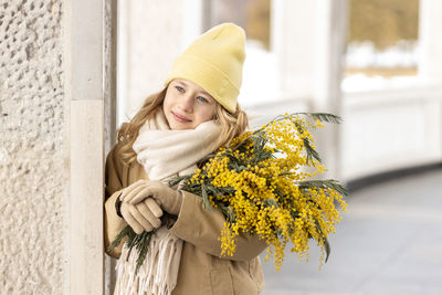 A girl  with a bouquet of mimosa in her hands. spring, international women's day march 8