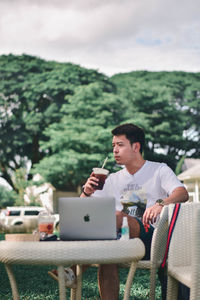 Young man using mobile phone while sitting on table