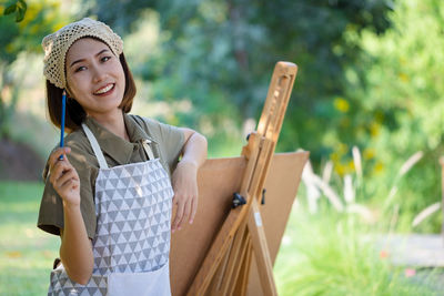 Portrait of a smiling young woman holding outdoors