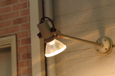 Close-up of electric lamp on wall at home