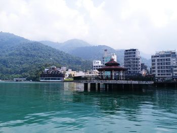 Scenic view of city by mountains against sky