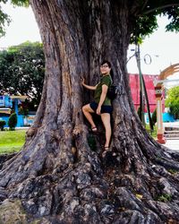 Woman sitting on tree trunk