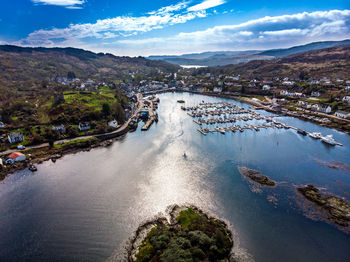 Aerial view of river amidst city against sky