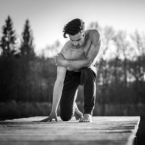 Young man exercising on jetty