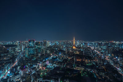 Aerial view of illuminated buildings in city against sky at night