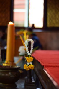 Close-up of garland and incense sticks at shrine