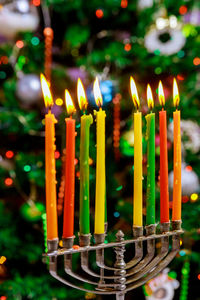 Close-up of burning candles on cutting board