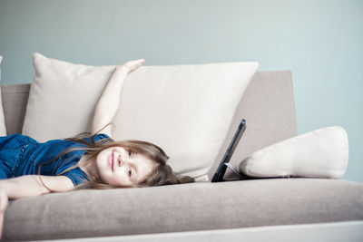 Portrait of girl lying on sofa at home