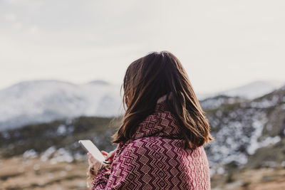 Rear view of woman standing on snow covered landscape