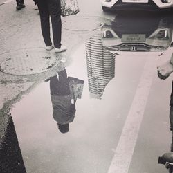 Low section of man standing on puddle