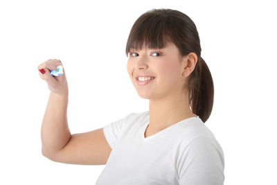 Close-up portrait of a smiling young woman over white background