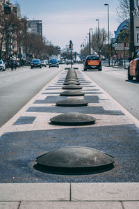 Cars on street in city against sky