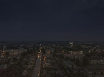 High angle view of illuminated buildings against sky at night