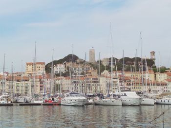 Boats moored at harbor against sky