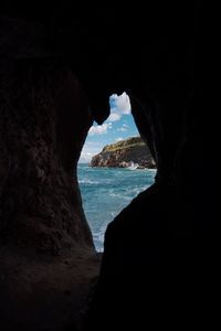 Scenic view of sea seen through cave