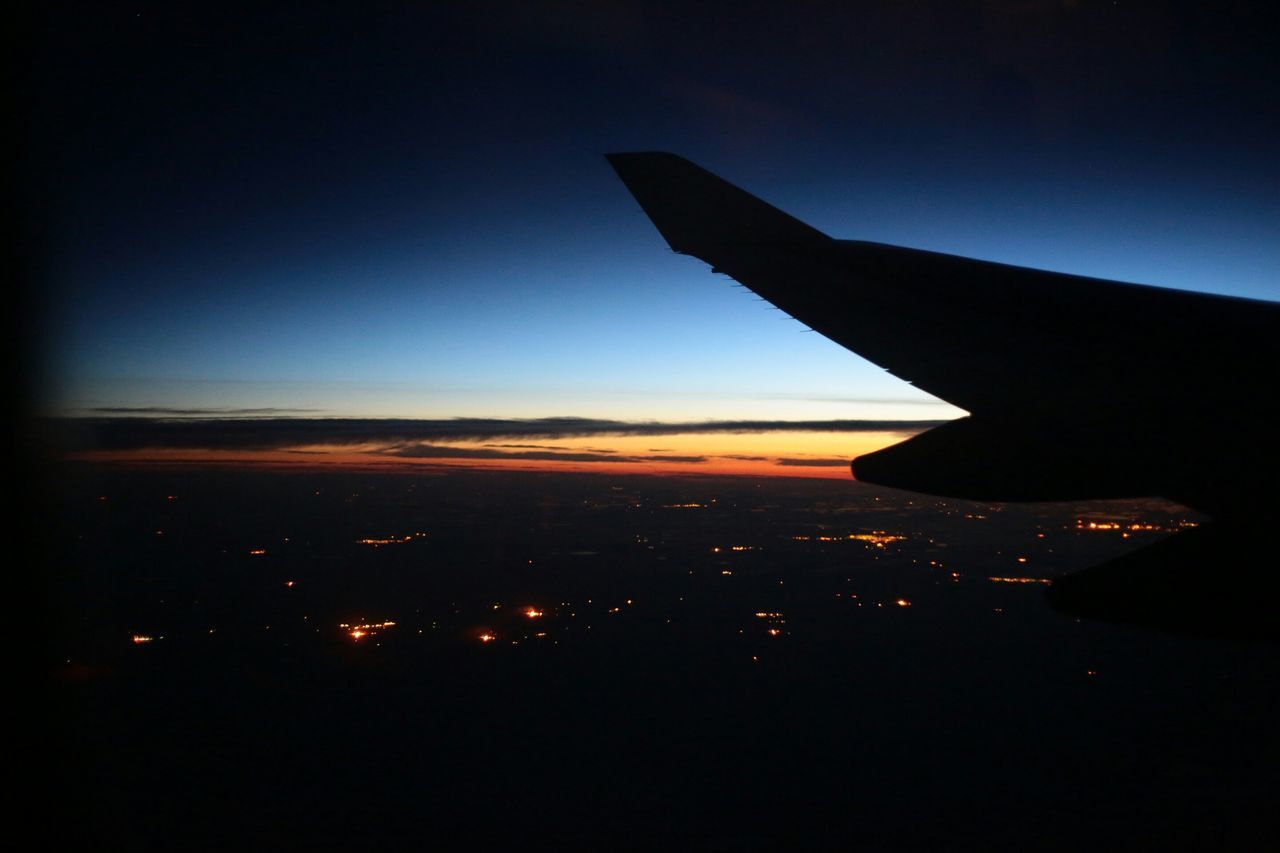 airplane, aircraft wing, air vehicle, flying, transportation, mode of transport, sky, part of, sunset, aerial view, mid-air, cropped, travel, landscape, scenics, journey, beauty in nature, on the move, silhouette, airplane wing