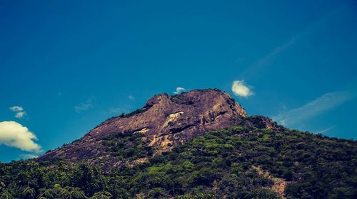 Low angle view of mountain range against cloudy sky