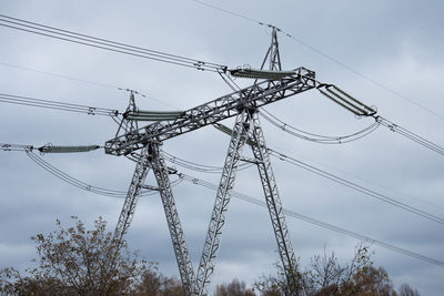 Low angle view of electricity pylon against sky