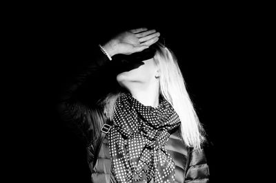 Woman standing against black background