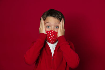 Close-up portrait of boy against red background