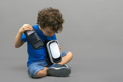Child with virtual reality goggles in his hands looking curiously at how they work