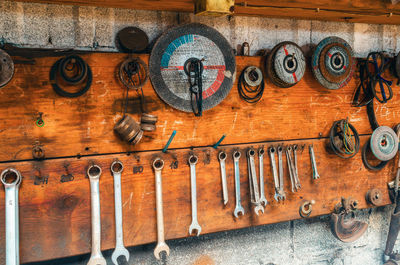 Old tools hang on wall in workshop, wrenches, grinding wheels. vintage garage style.