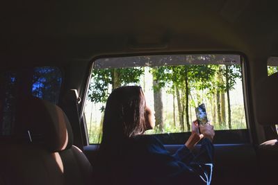 Rear view of woman sitting in car