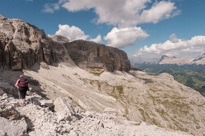 Man on rock formations against sky