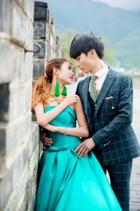 Romantic young couple standing by wall