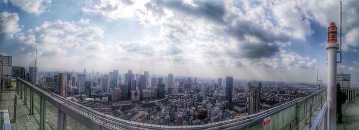 View of cityscape against cloudy sky