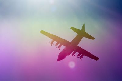 Low angle view of airplane flying against sky