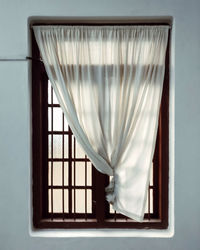 Close-up of white curtain against window at home