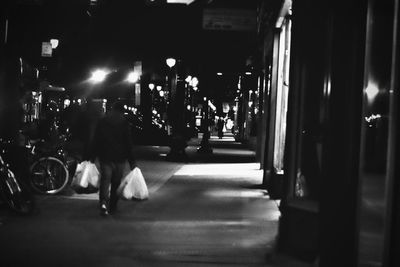 Man walking on illuminated street at night