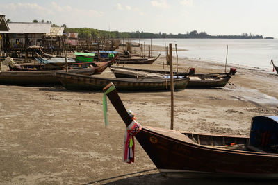 Boat moored on beach against sky