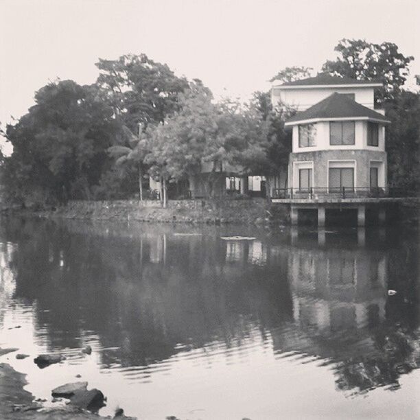 water, reflection, tree, built structure, architecture, building exterior, waterfront, lake, clear sky, tranquility, tranquil scene, nature, house, sky, standing water, beauty in nature, scenics, day, outdoors, river