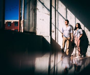 Creative photoshoot with couple standing against wall