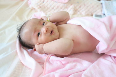 High angle portrait of baby lying on bed