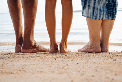 Low section of man standing on beach