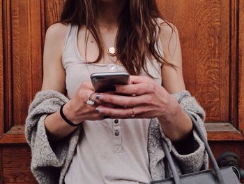 Midsection of woman using mobile phone