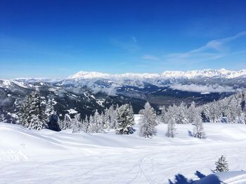 Snow covered mountains against blue sky